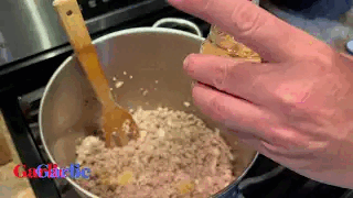 Stirring ground beef chili in a pot with a wooden spoon, still from the Barbaro Mojo chili video
