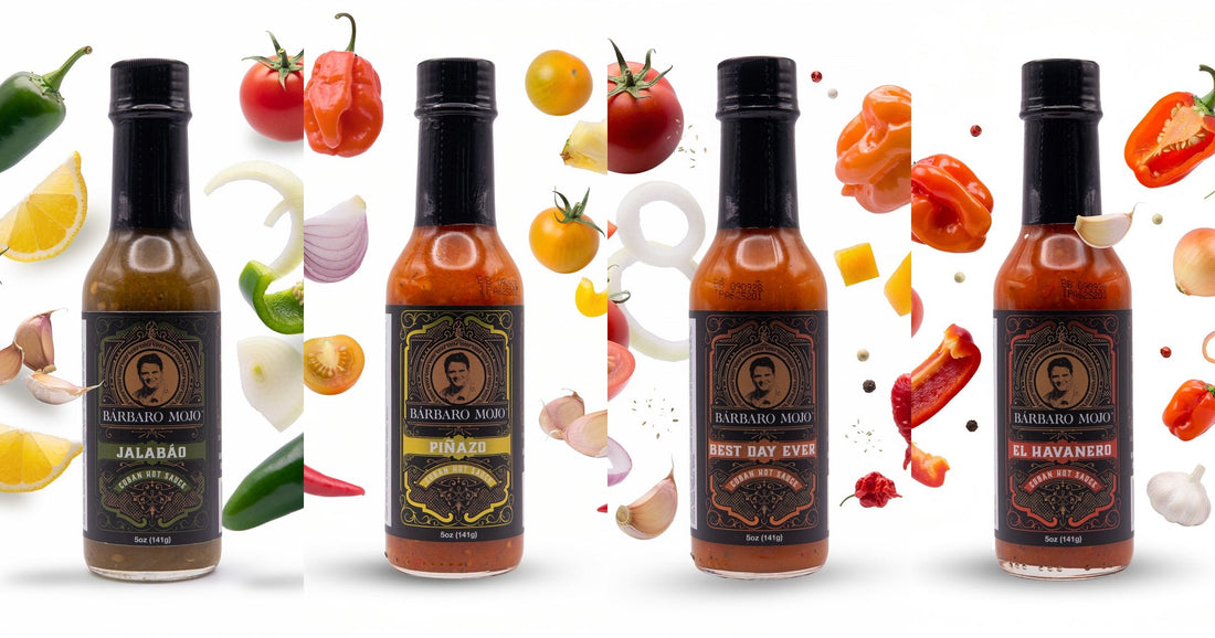 Four Barbaro Mojo bottles, Jalabáo, Piñazo, Best Day Ever and El Havanero, each surrounded by the fresh peppers, vegetables and fruit that go into it