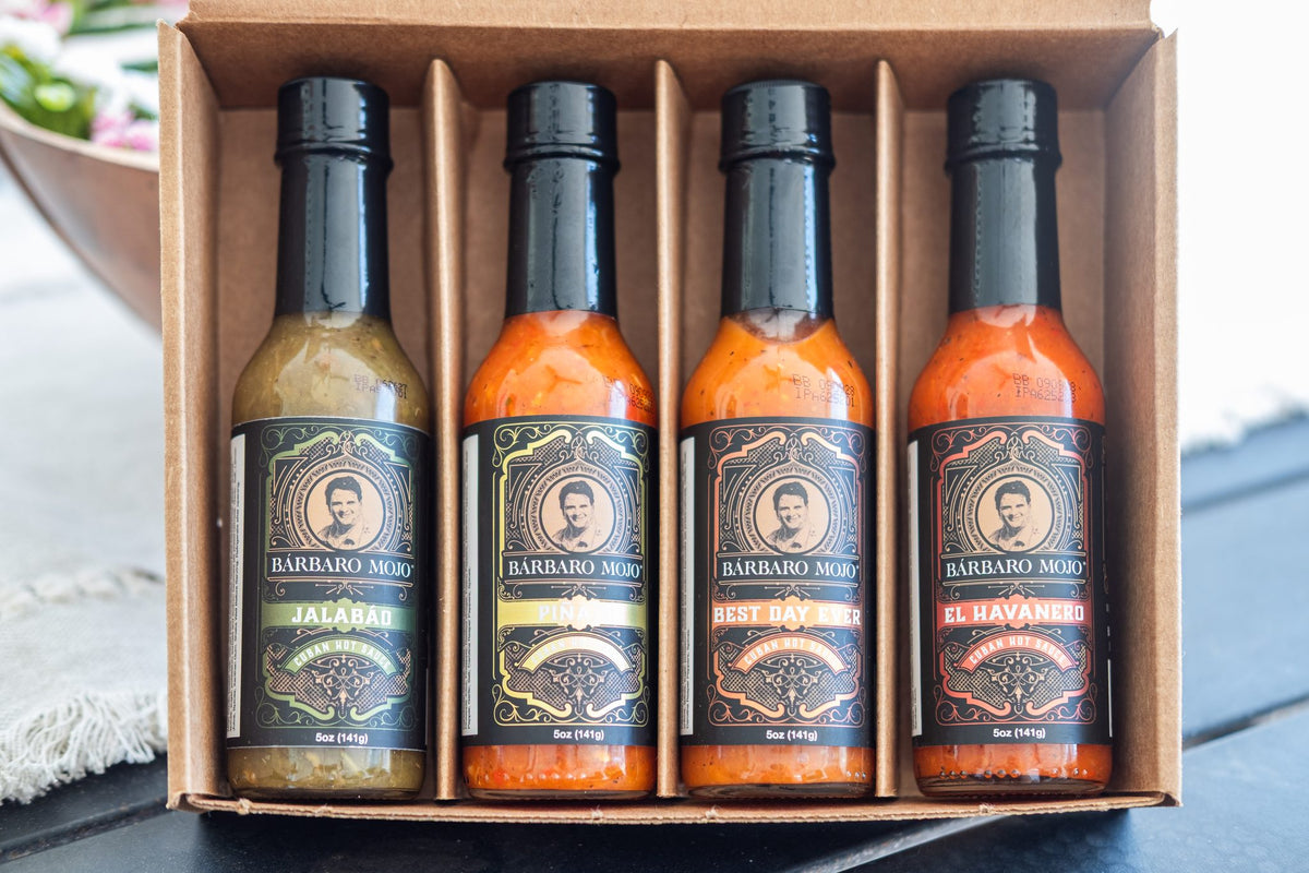 Open kraft gift box with four Barbaro Mojo hot sauces: Jalabáo, Piñazo, Best Day Ever and El Havanero